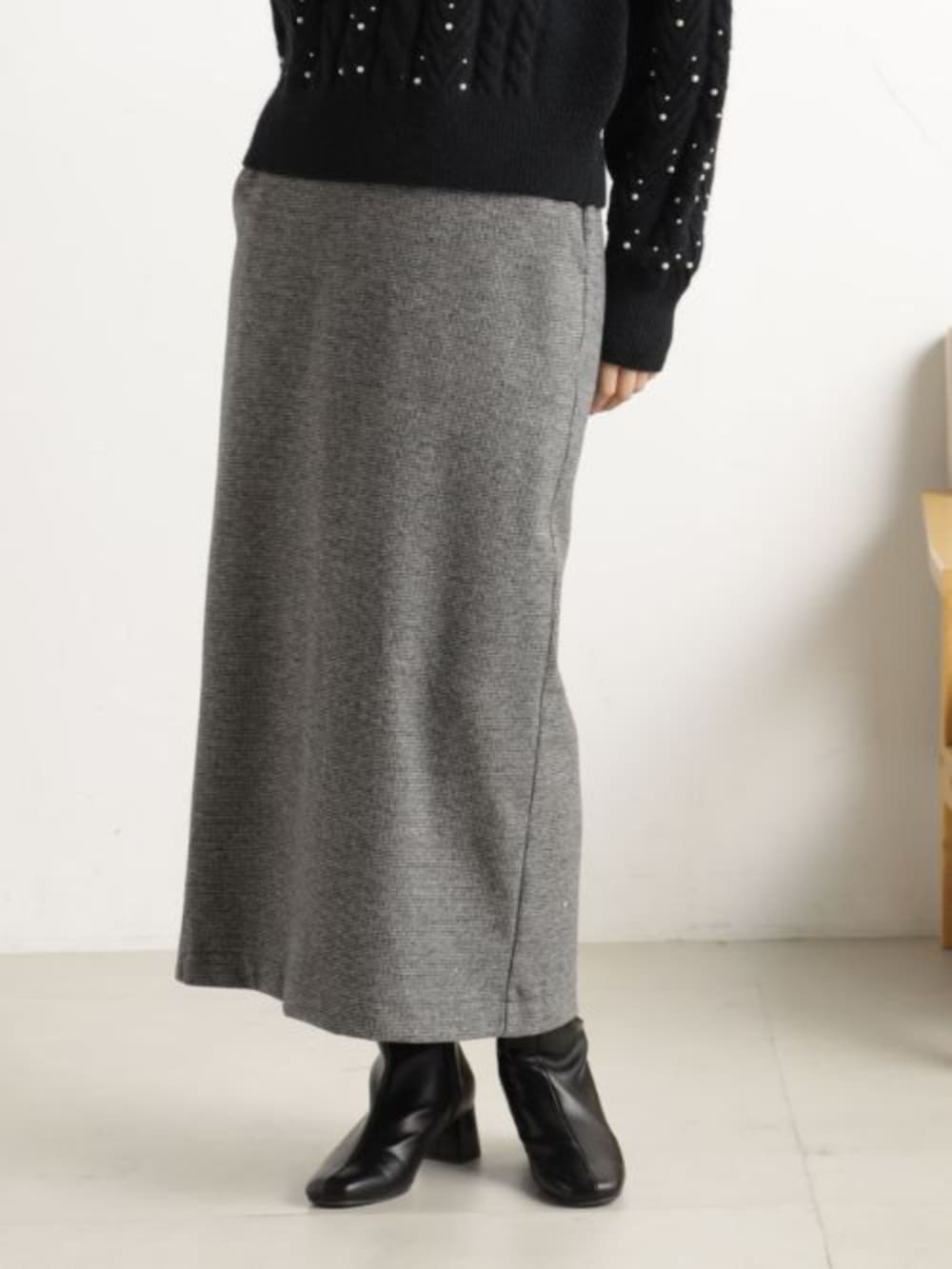 ブラック系のブーツ、ブラック系のショルダーバッグ、グレー系のスカートを着用したレディースの冬コーディネートの2枚目の写真