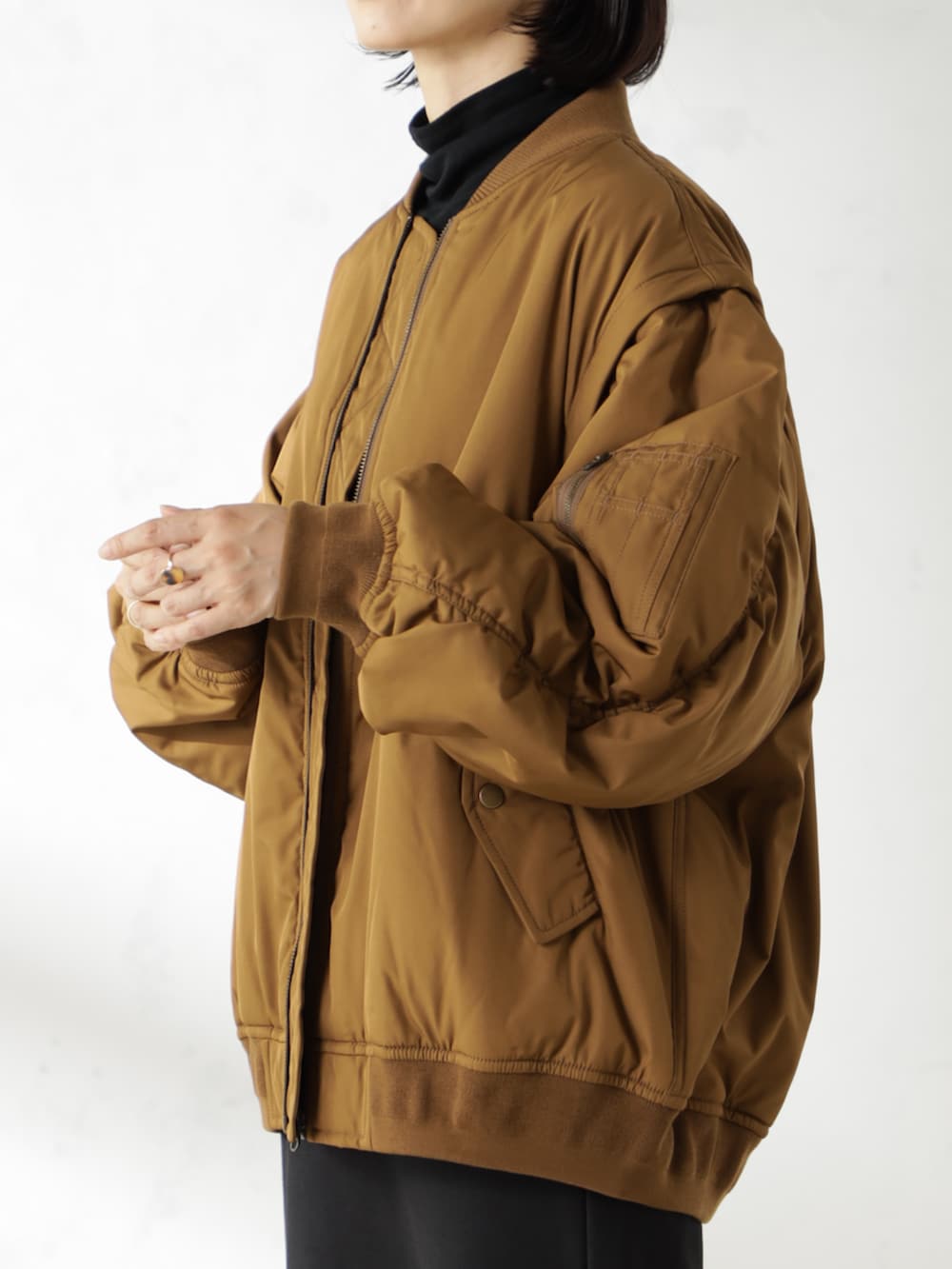 ブラック系のブーツ、ブラウン系のMA-1、ブラック系のスカートを着用したレディースの秋コーディネートの2枚目の写真