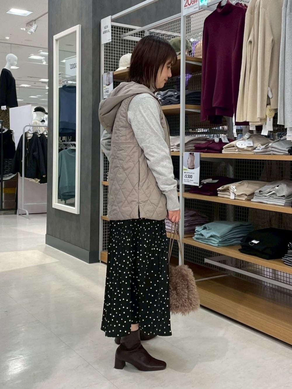 ブラウン系のエコバッグ/サブバッグ、ブラウン系のベスト、グレー系のスカートを着用したレディースの冬コーディネートの2枚目の写真