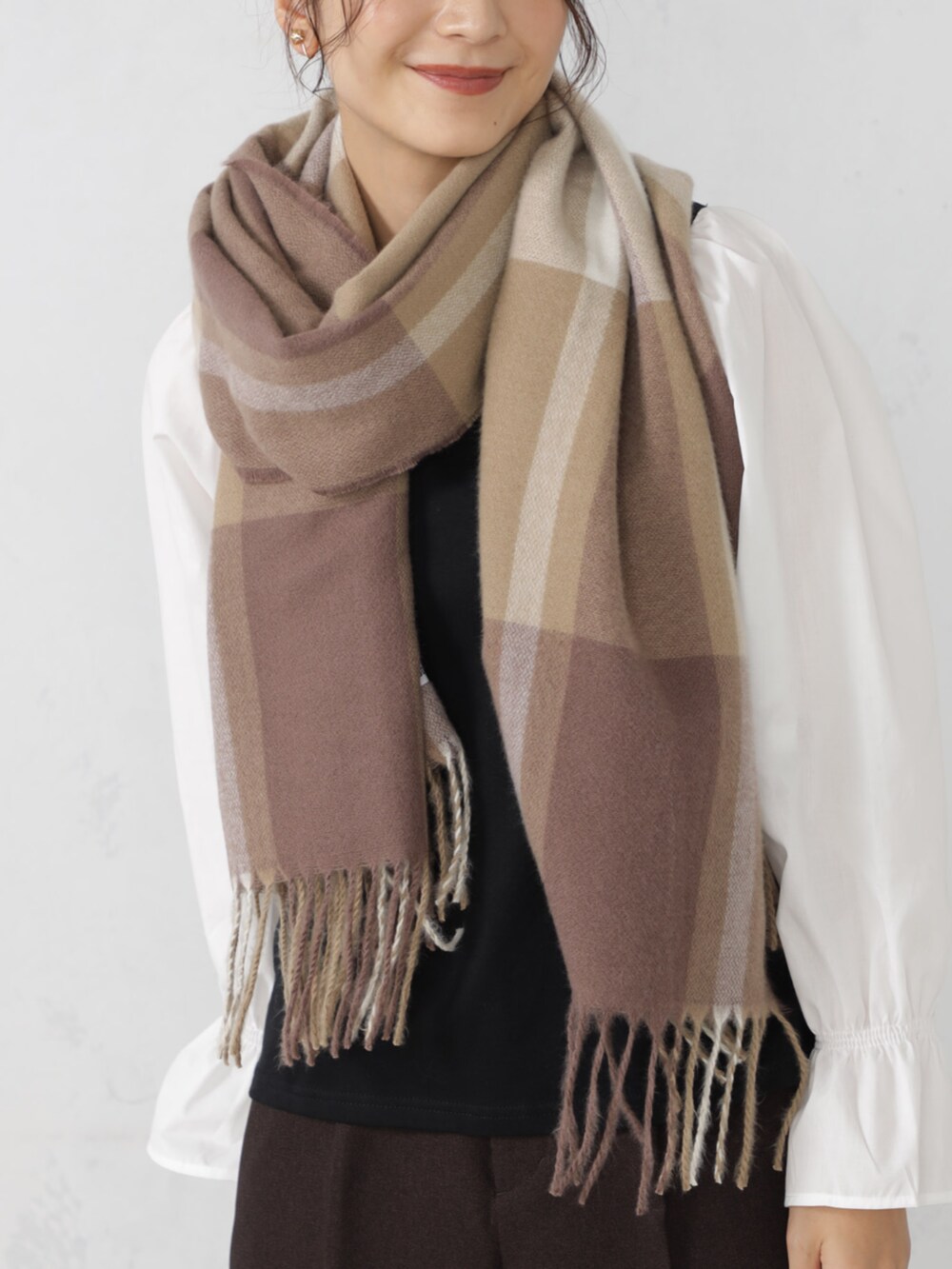 ブラウン系のマフラーを着用したレディースの秋コーディネートの2枚目の写真
