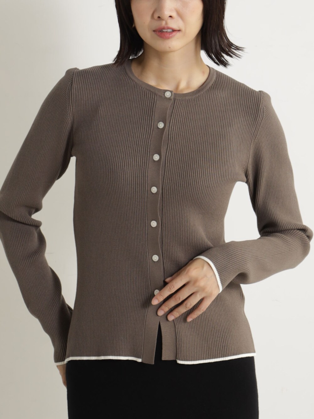 ブラック系のスカート、ベージュ系のブーツ、グレー系のカーディガン/ボレロを着用したレディースの冬コーディネートの2枚目の写真