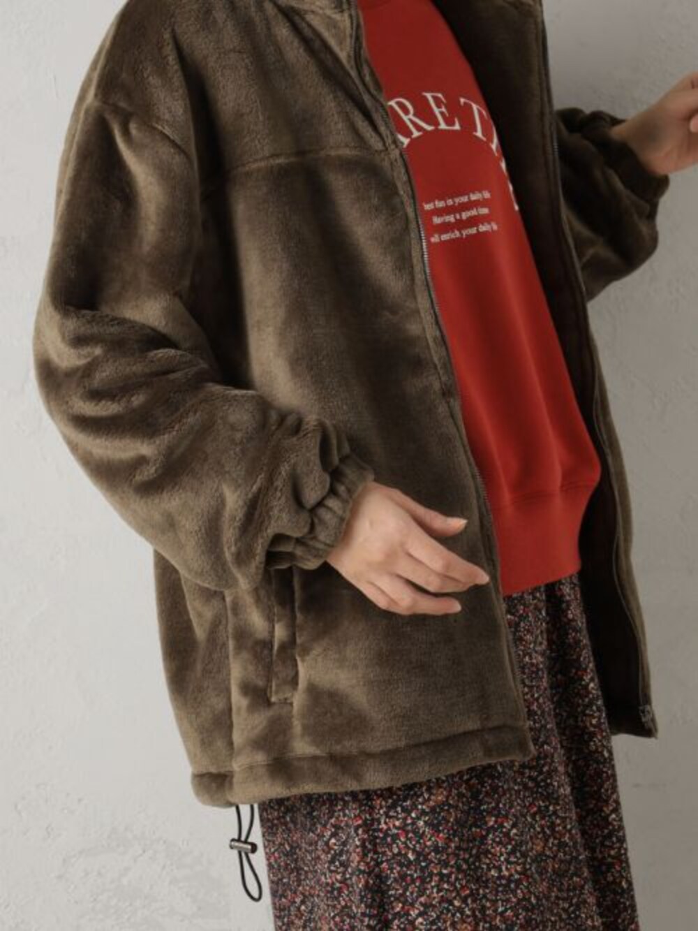 ブラック系のブーツ、レッド系のスウェット、レッド系のスカートを着用したレディースの冬コーディネートの2枚目の写真