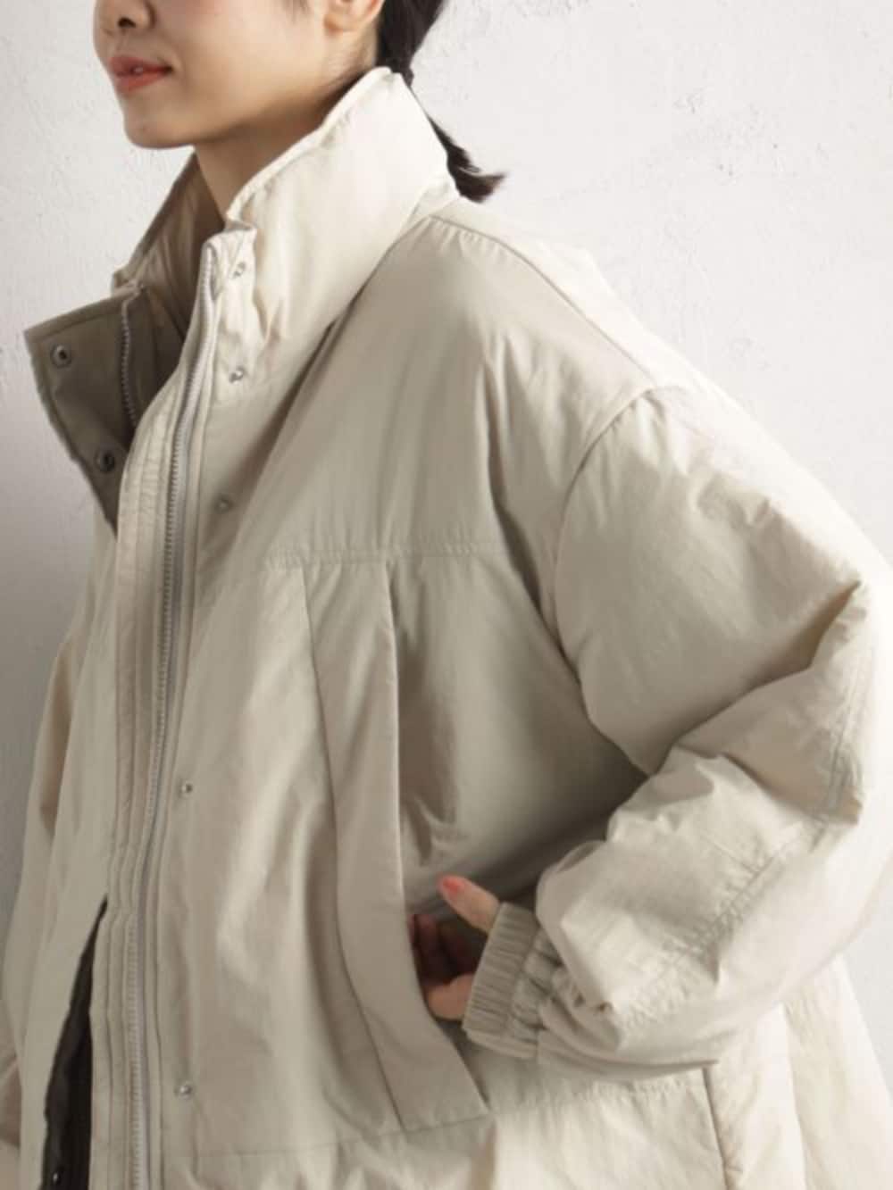 ブラック系のショルダーバッグ、ブルー系のその他パンツ、ベージュ系のその他アウターを着用したレディースの冬コーディネートの3枚目の写真