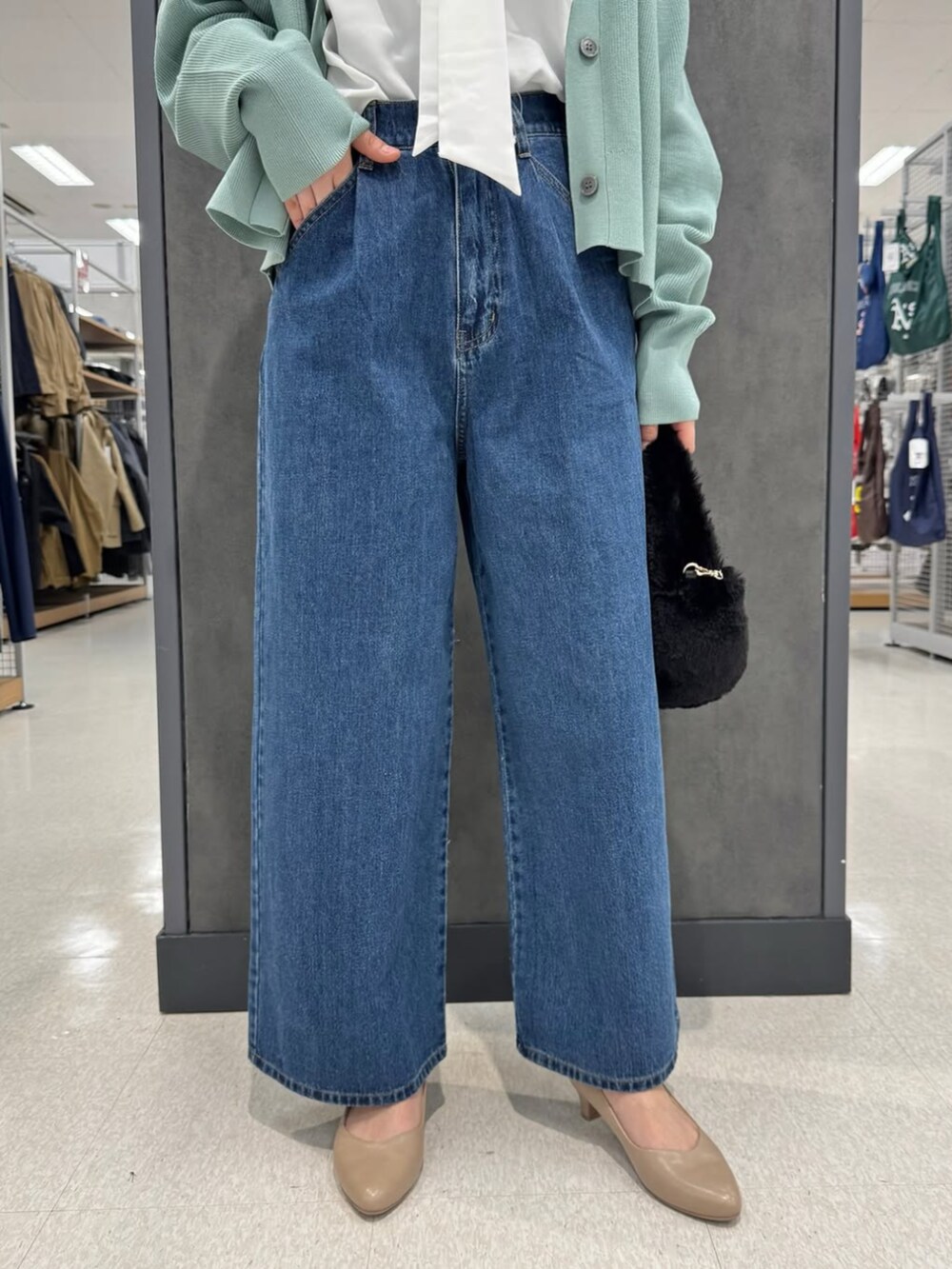 グリーン系のカーディガン/ボレロ、ブルー系のデニムパンツ、ホワイト系のシャツ/ブラウスを着用したレディースの冬コーディネートの2枚目の写真