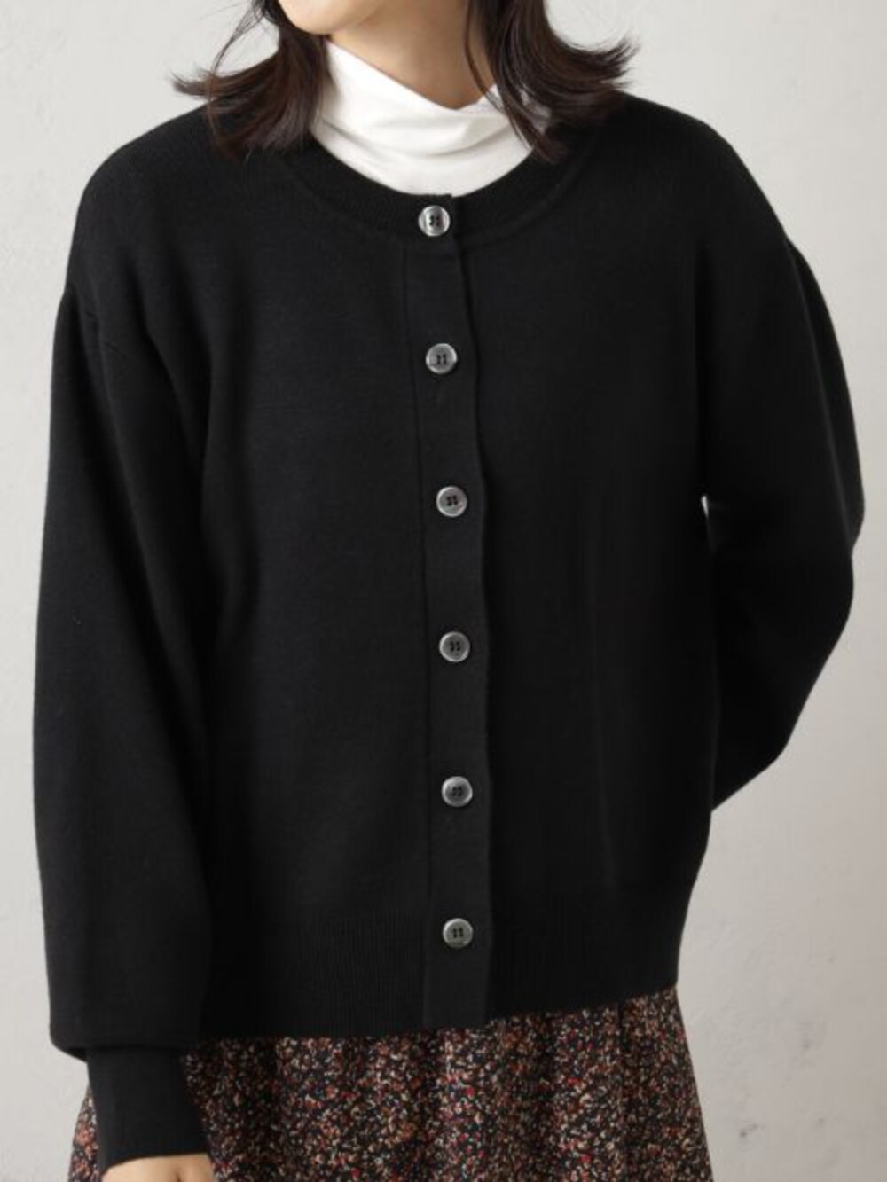 ブラック系のボストンバッグ、レッド系のスカート、ブラック系のカーディガン/ボレロを着用したレディースの冬コーディネートの2枚目の写真