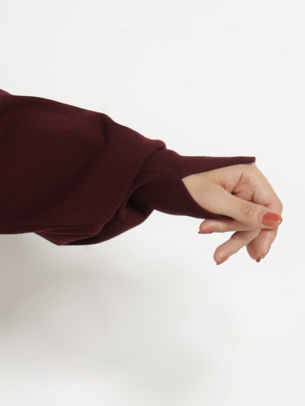 ブラック系のショルダーバッグ、レッド系のニット/セーター、ブラック系のスカートを着用したレディースの秋コーディネートの4枚目の写真