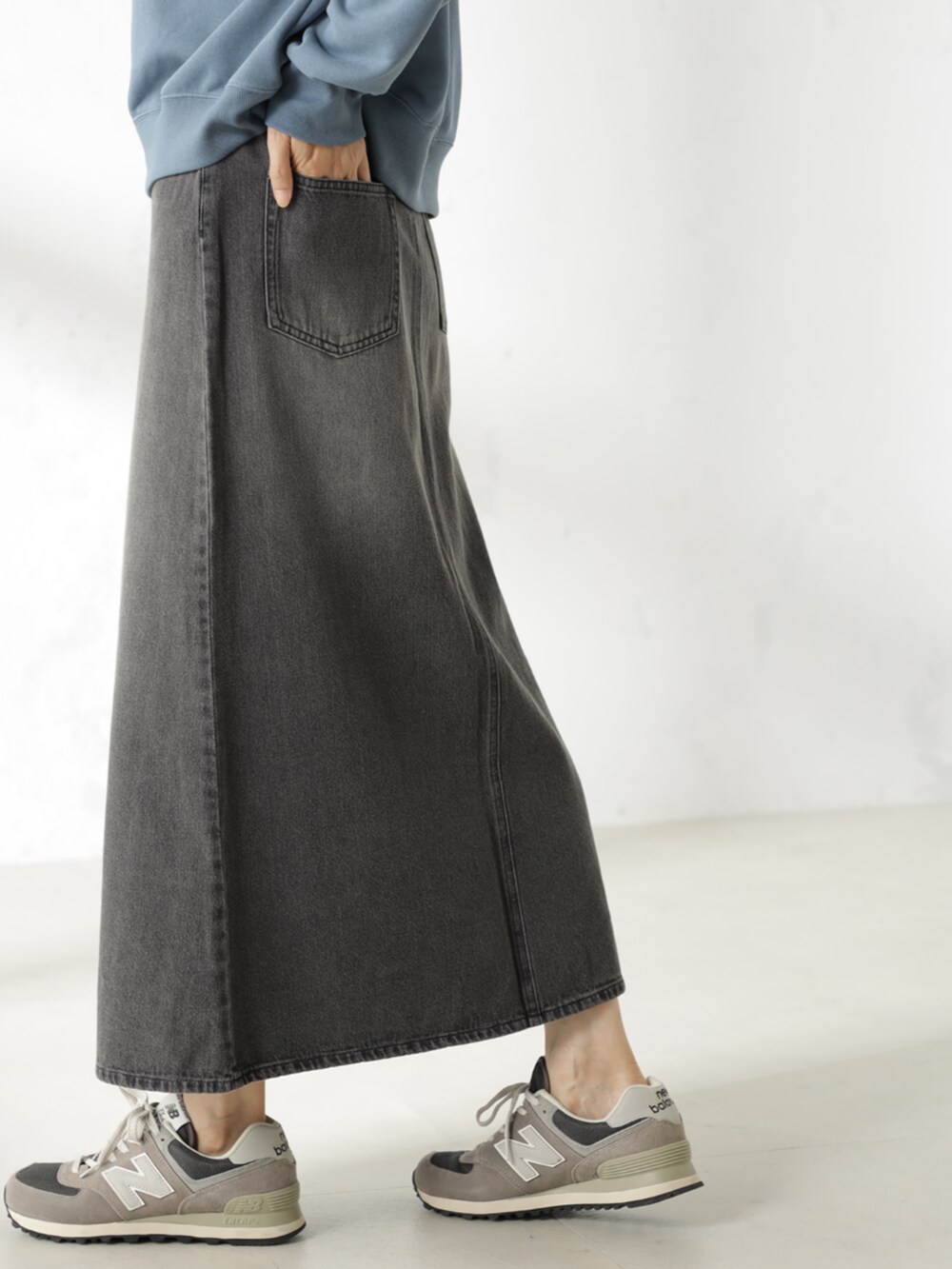 グレー系のスカート、ブルー系のスウェットを着用したレディースの冬コーディネートの4枚目の写真