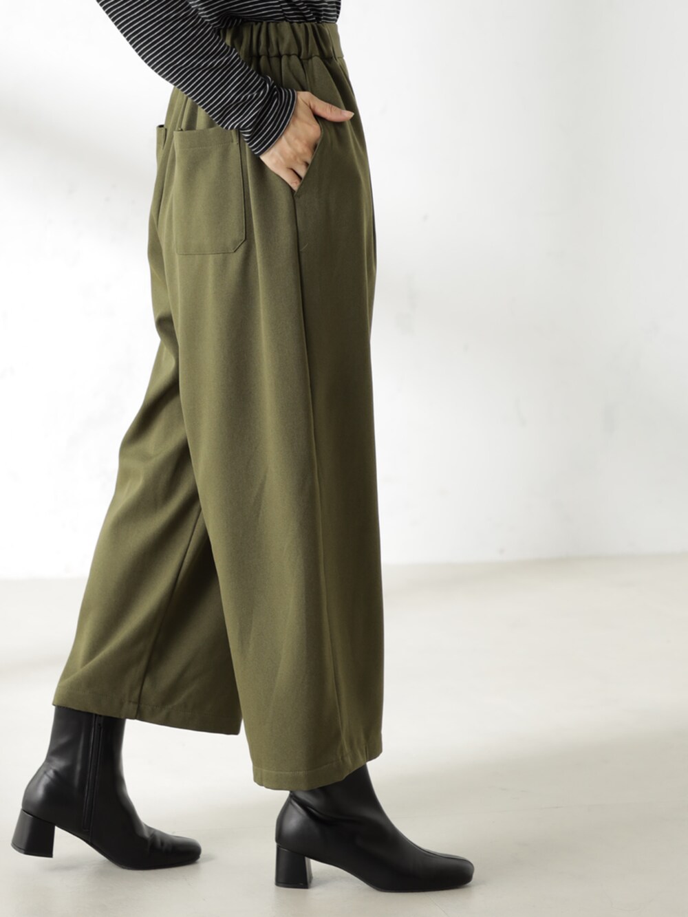 ブラック系のブーツ、グレー系のTシャツ/カットソー、グリーン系のその他パンツを着用したレディースの冬コーディネートの3枚目の写真