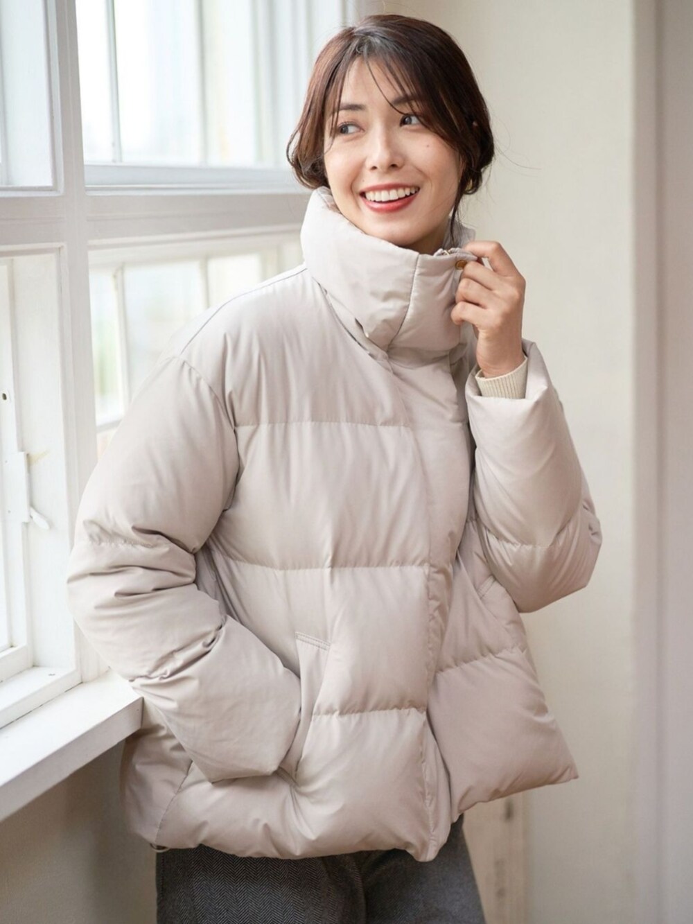 ベージュ系のダウンジャケット/コートを着用したレディースの冬コーディネートの2枚目の写真