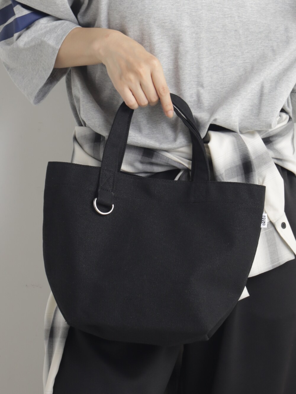 ブラック系のトートバッグを着用したレディースの春コーディネートの2枚目の写真