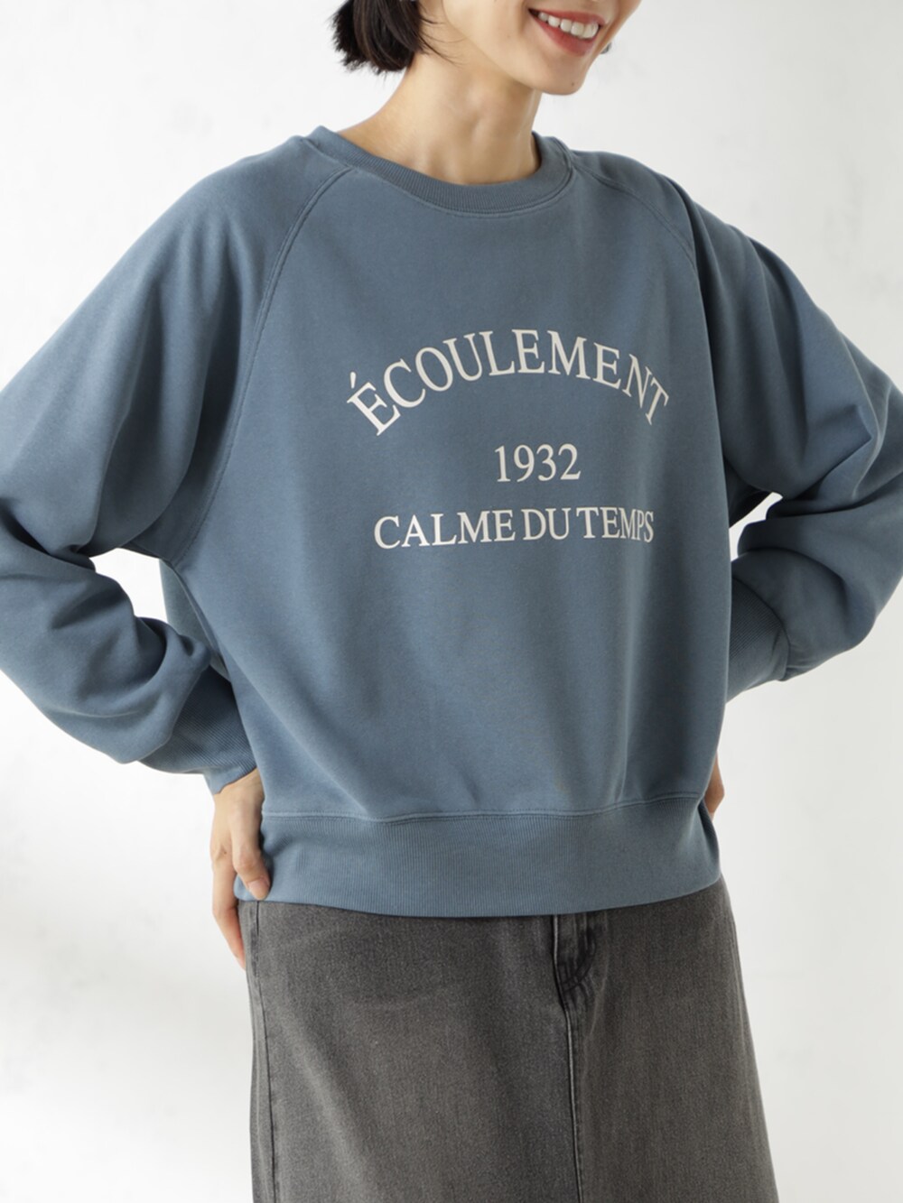 グレー系のスカート、ブルー系のスウェットを着用したレディースの冬コーディネートの2枚目の写真