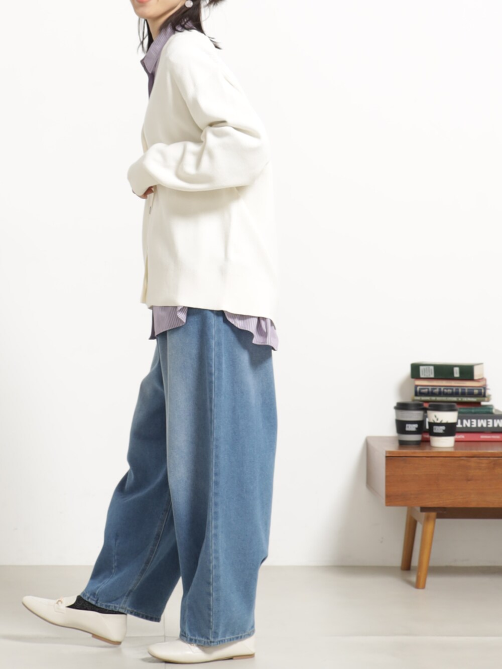 ブルー系のデニムパンツ、ホワイト系のカーディガン/ボレロ、パープル系のシャツ/ブラウスを着用したレディースの秋コーディネートの2枚目の写真