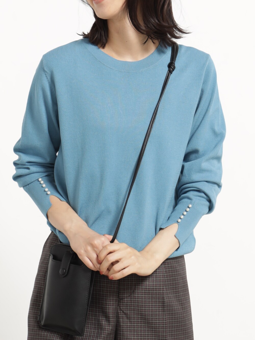 ブラウン系のその他パンツ、ブルー系のニット/セーター、ブラック系のショルダーバッグを着用したレディースの秋コーディネートの2枚目の写真