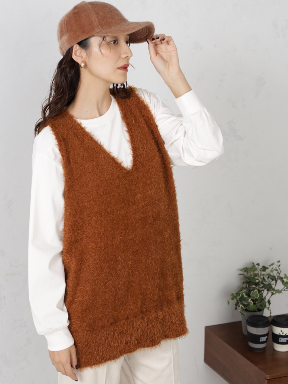 ブラウン系のニット/セーター、ブラウン系のキャップを着用したレディースの秋コーディネートの2枚目の写真