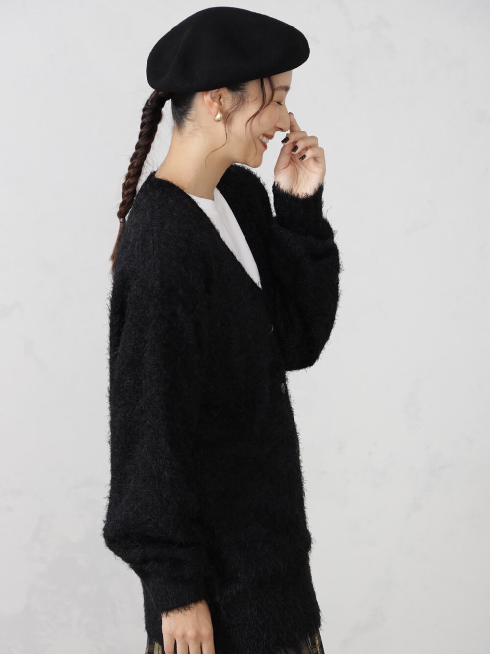 ブラウン系のスカート、ブラック系のカーディガン/ボレロ、ブラック系のハンチング/ベレー帽を着用したレディースの秋コーディネートの2枚目の写真