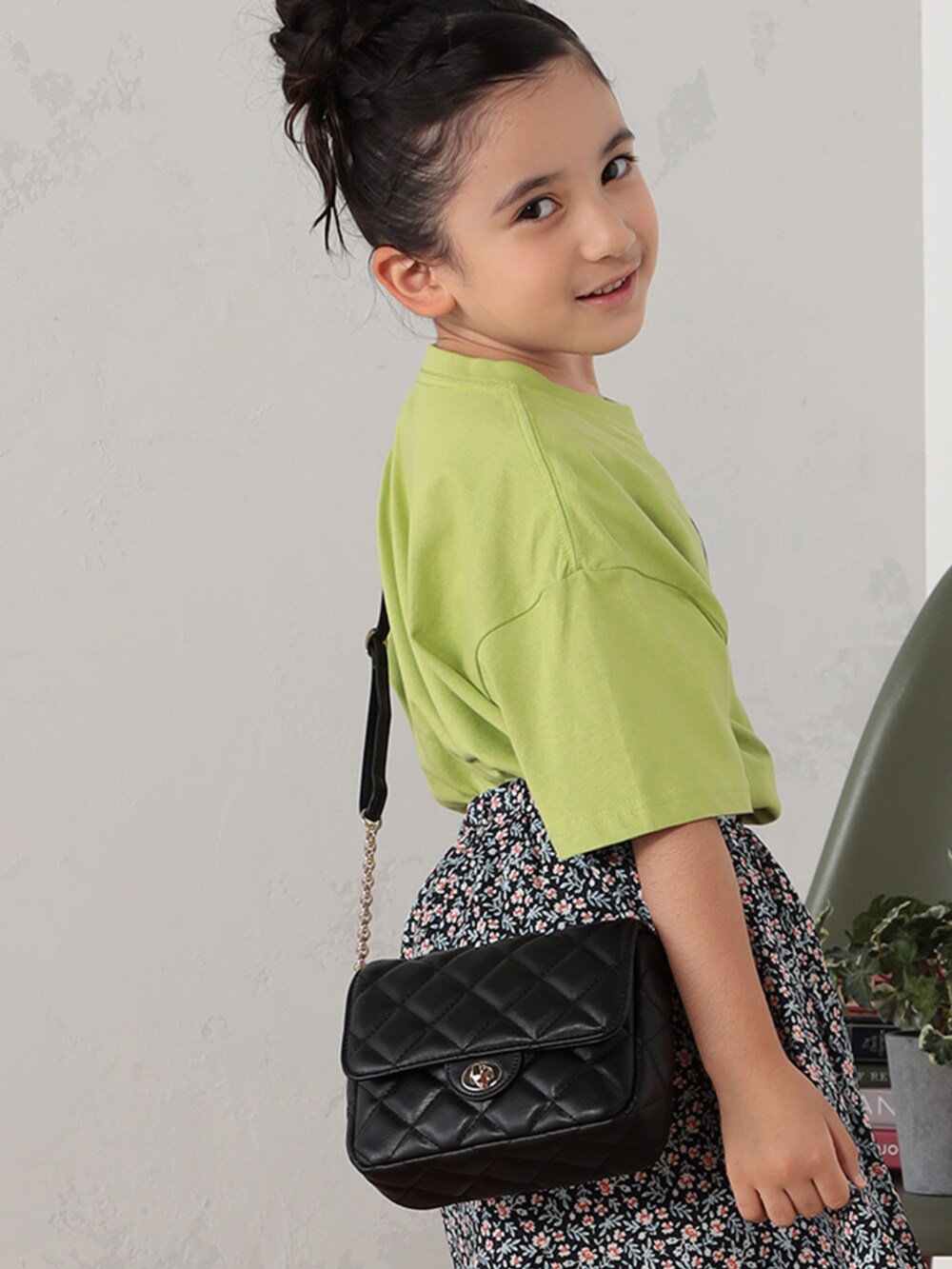 ブラック系のスカート、ブラック系のショルダーバッグを着用したキッズの秋コーディネートの2枚目の写真