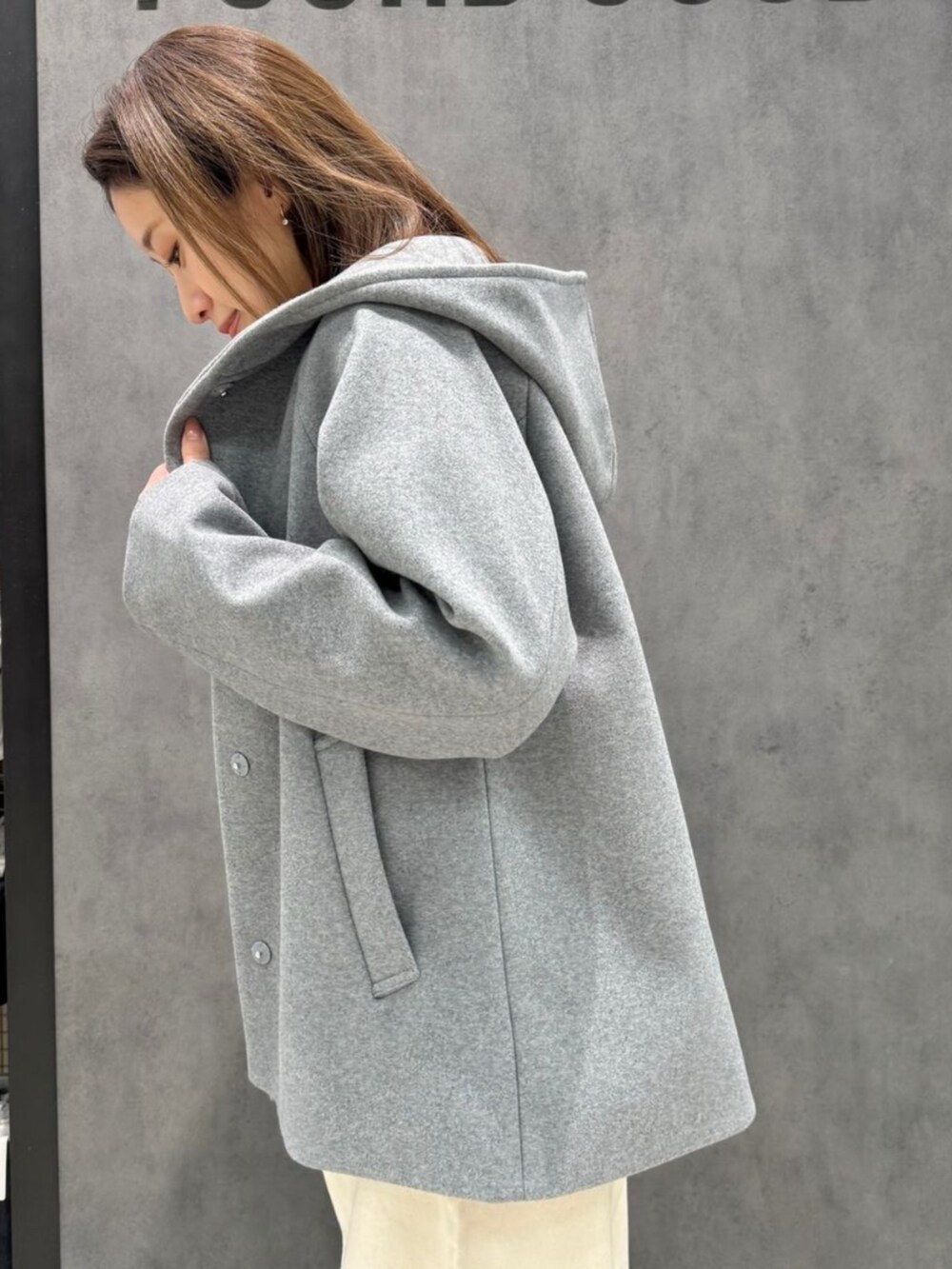 オレンジ系のニット/セーター、グレー系のその他アウターを着用したレディースの冬コーディネートの2枚目の写真