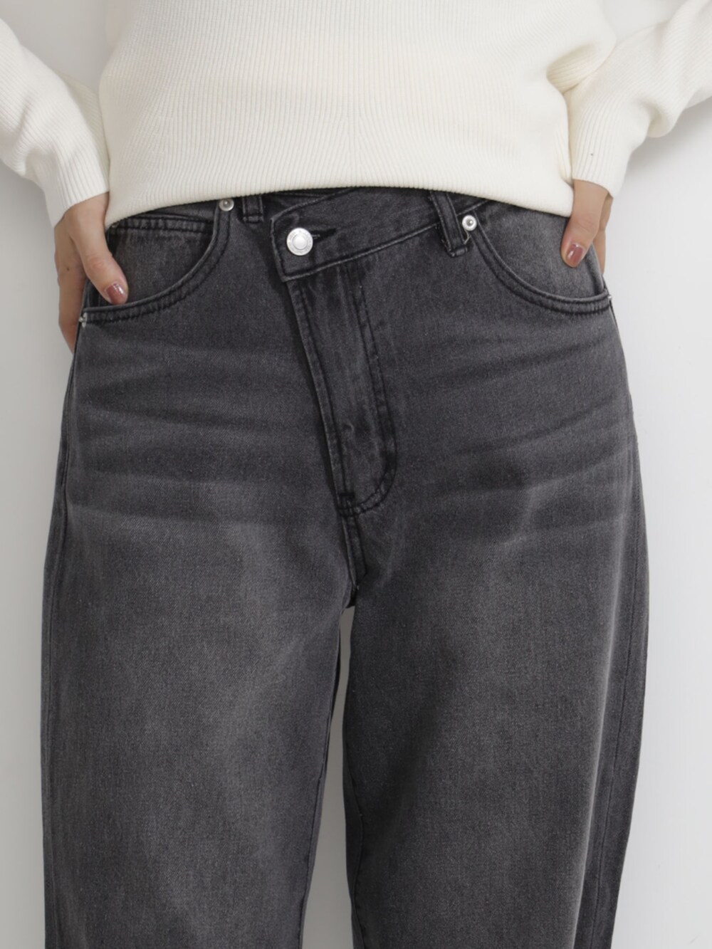 ブラック系のボストンバッグ、ブルー系のデニムパンツ、ホワイト系のニット/セーターを着用したレディースの秋コーディネートの3枚目の写真