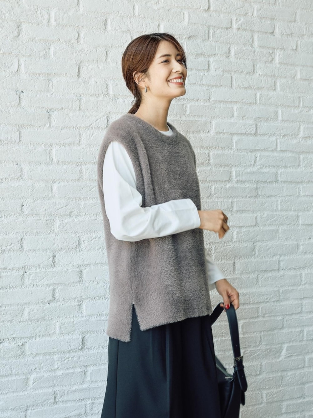 グレー系のベストを着用したレディースの秋コーディネートの2枚目の写真