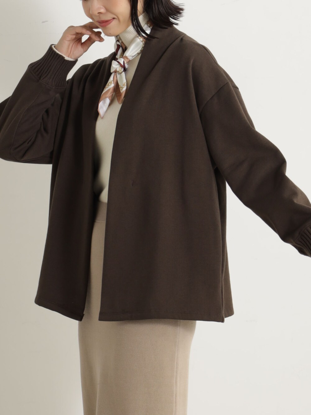 ブラウン系のスカート、ブラウン系のカーディガン/ボレロを着用したレディースの冬コーディネートの2枚目の写真