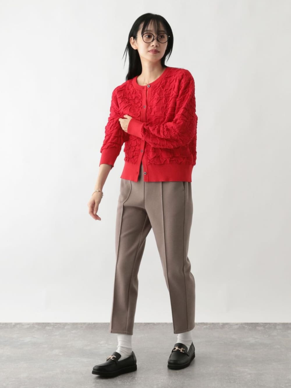 レッド系のカーディガン/ボレロを着用したレディースの秋コーディネートの2枚目の写真