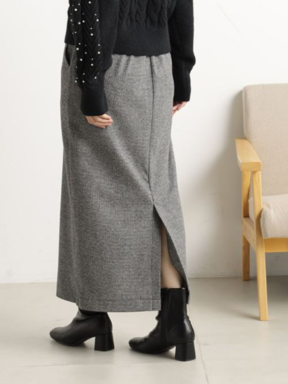 ブラック系のブーツ、ブラック系のショルダーバッグ、グレー系のスカートを着用したレディースの冬コーディネートの3枚目の写真