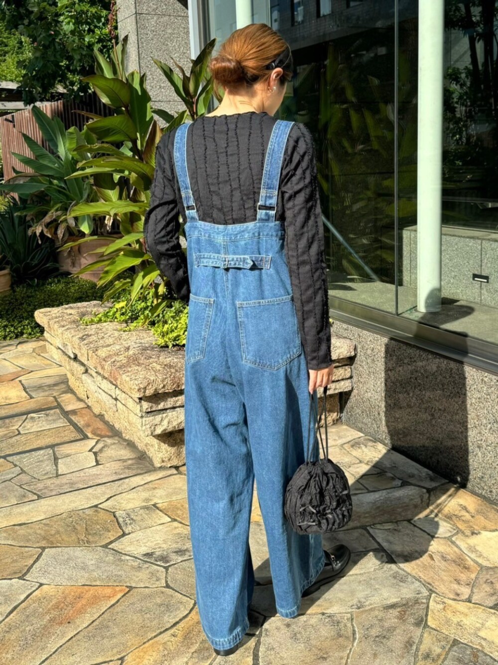 ブルー系のサロペット/オーバーオール、ブラック系のTシャツ/カットソーを着用したレディースの秋コーディネートの2枚目の写真