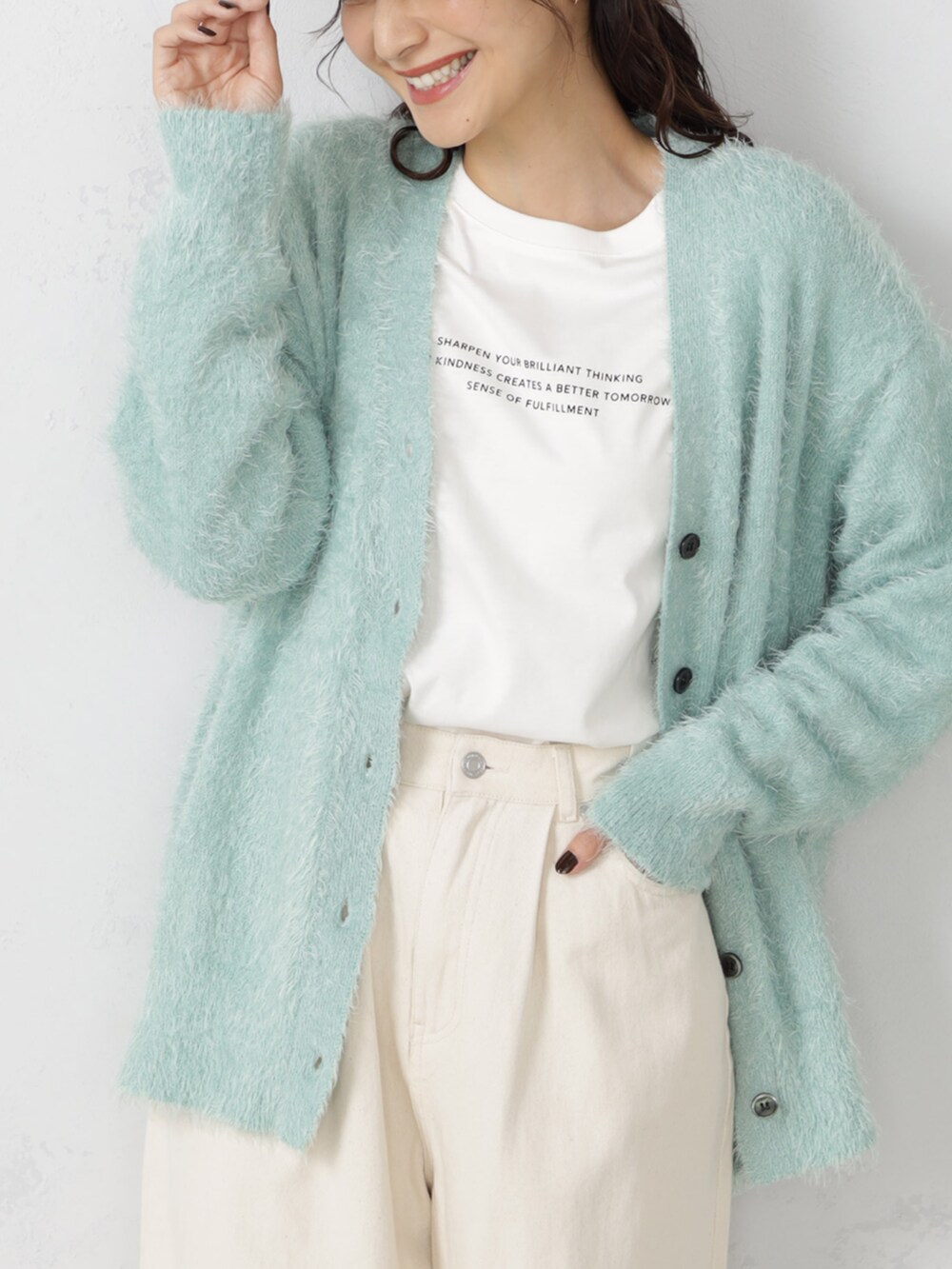 ベージュ系のチノパンツ、グリーン系のカーディガン/ボレロを着用したレディースの秋コーディネートの2枚目の写真