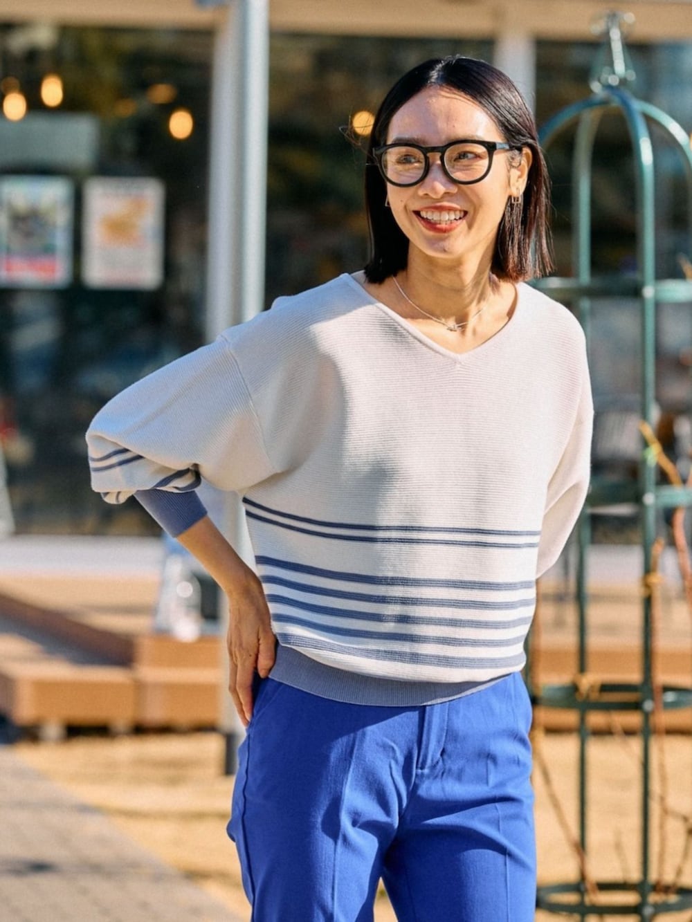 ブルー系のニット/セーターを着用したレディースの春コーディネートの2枚目の写真