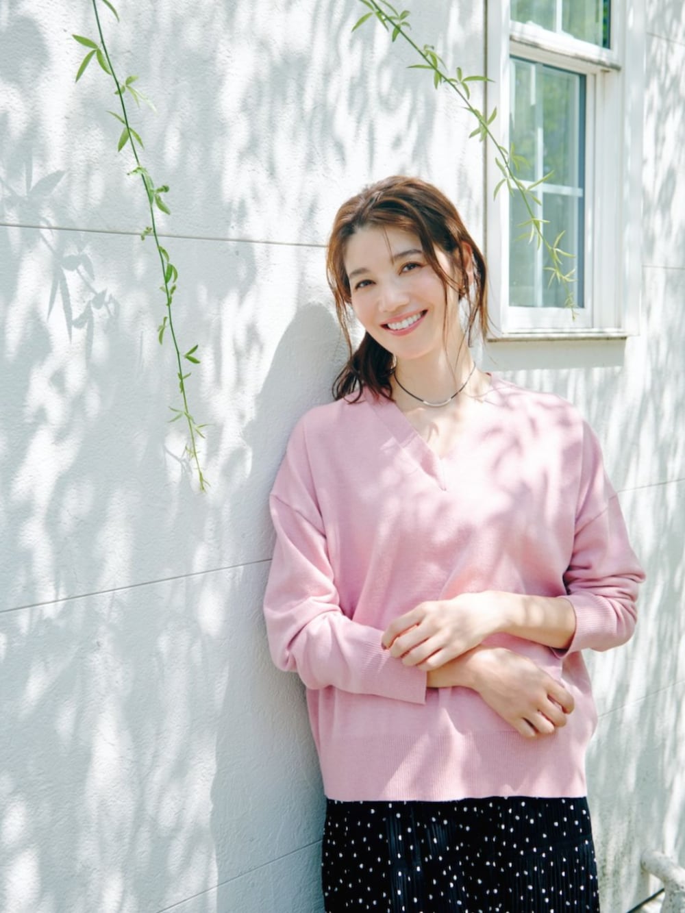 ピンク系のニット/セーターを着用したレディースの秋コーディネートの2枚目の写真