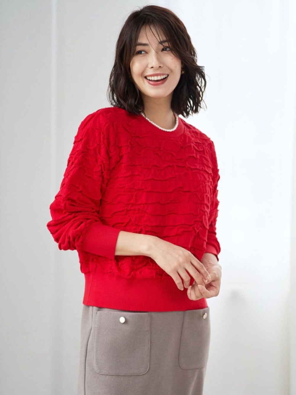 レッド系のニット/セーターを着用したレディースの冬コーディネートの2枚目の写真