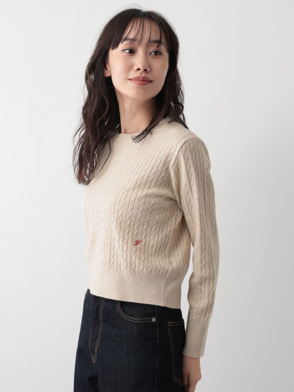 ベージュ系のニット/セーターを着用したレディースの冬コーディネートの2枚目の写真