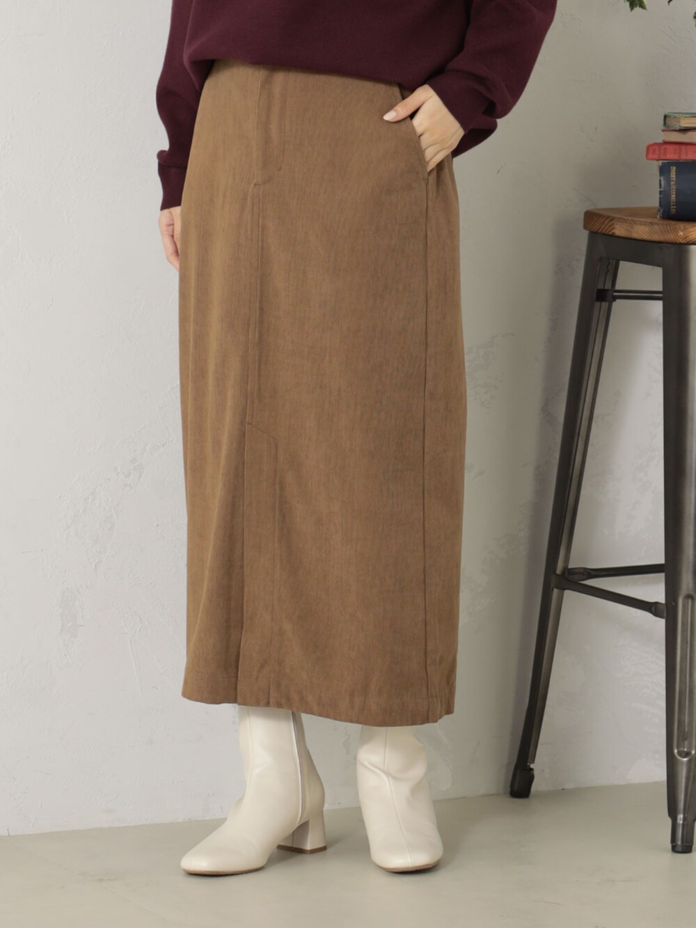 ベージュ系のブーツ、レッド系のニット/セーター、ベージュ系のスカートを着用したレディースの冬コーディネートの3枚目の写真