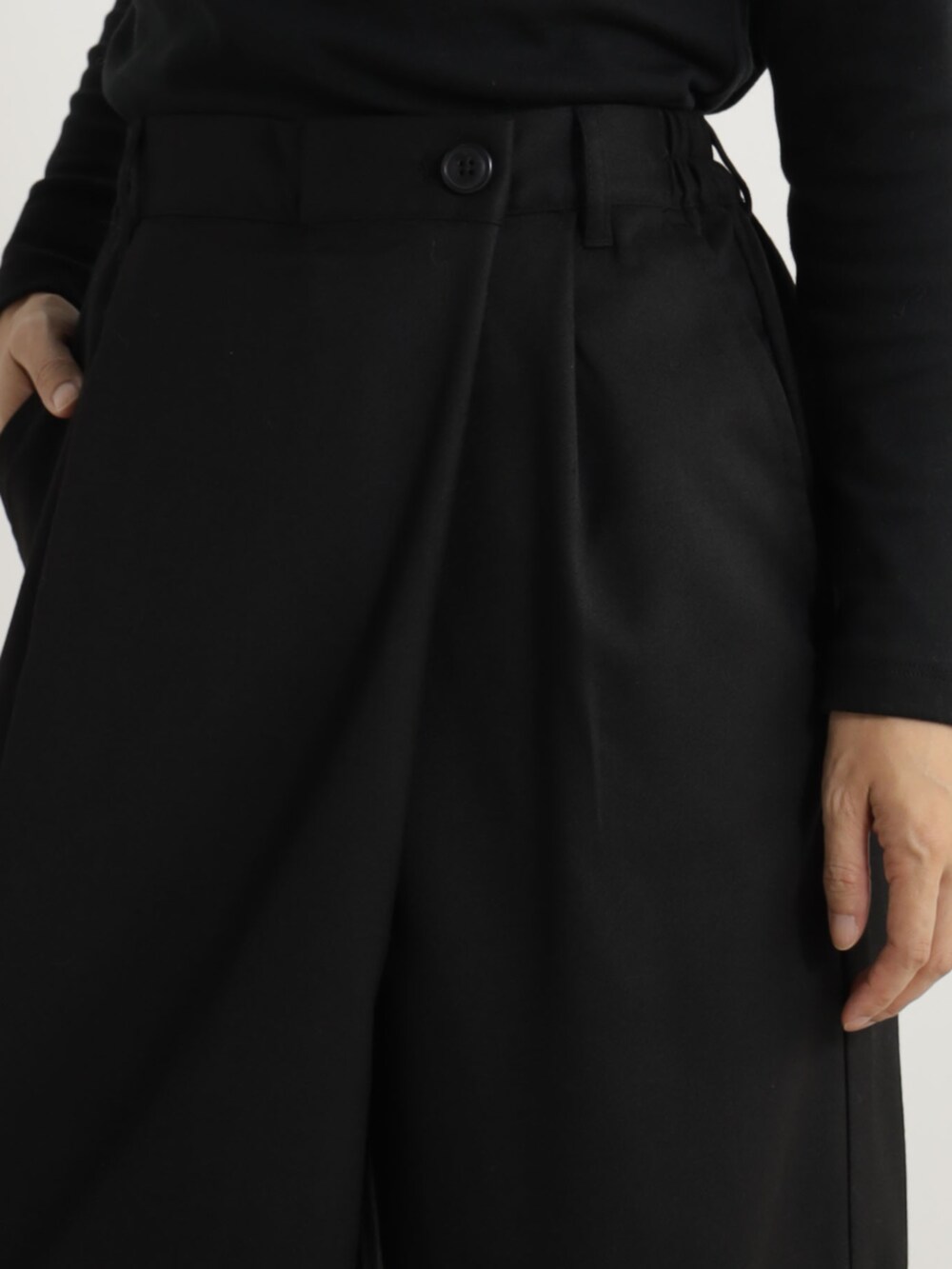 ブラック系のパンプス、ブラック系のTシャツ/カットソー、ブラック系のその他パンツを着用したレディースの冬コーディネートの3枚目の写真