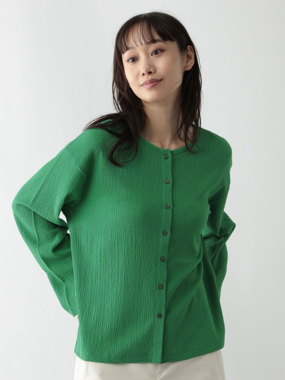 グリーン系のカーディガン/ボレロを着用したレディースの秋コーディネートの2枚目の写真