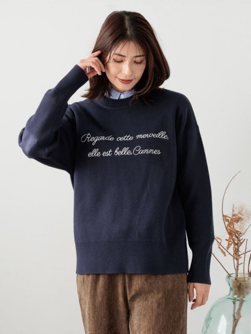 ブルー系のニット/セーターを着用したレディースの冬コーディネートの2枚目の写真