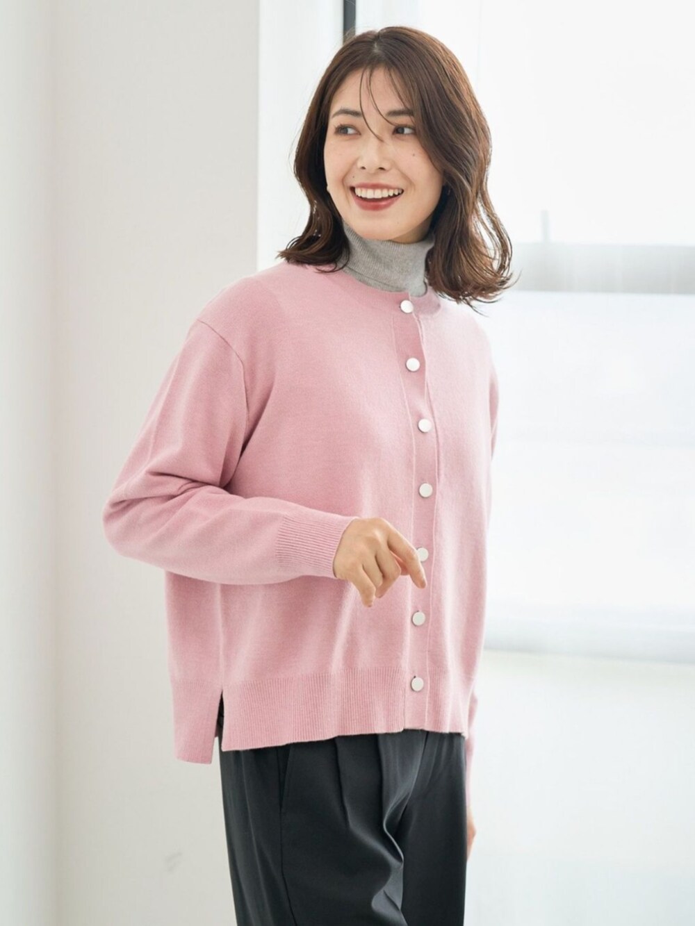 ピンク系のカーディガン/ボレロを着用したレディースの冬コーディネートの2枚目の写真