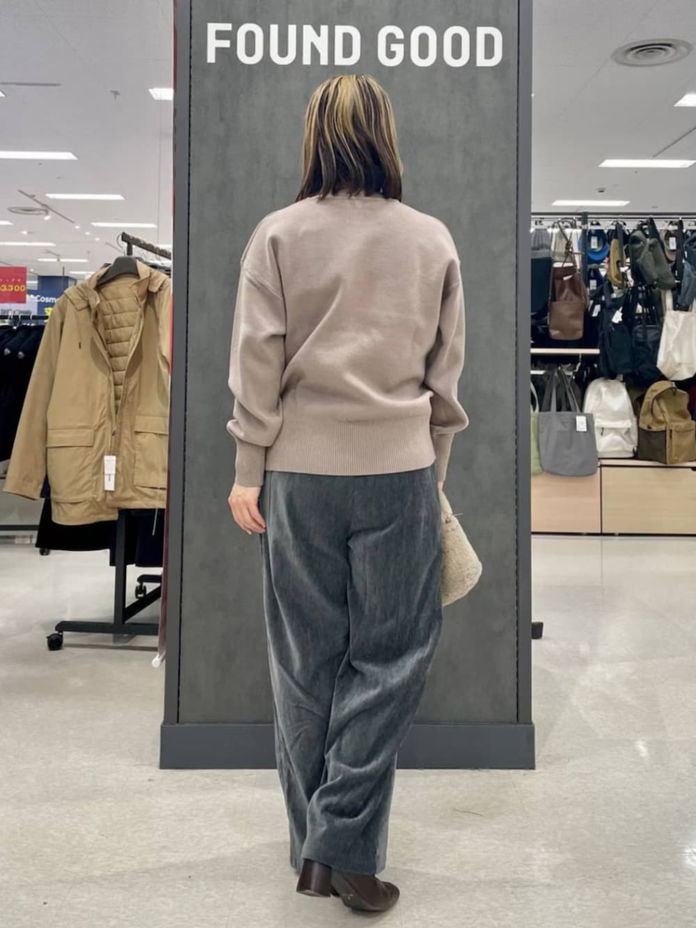 ベージュ系のハンドバッグ、ベージュ系のニット/セーター、グレー系のその他パンツを着用したレディースの冬コーディネートの3枚目の写真