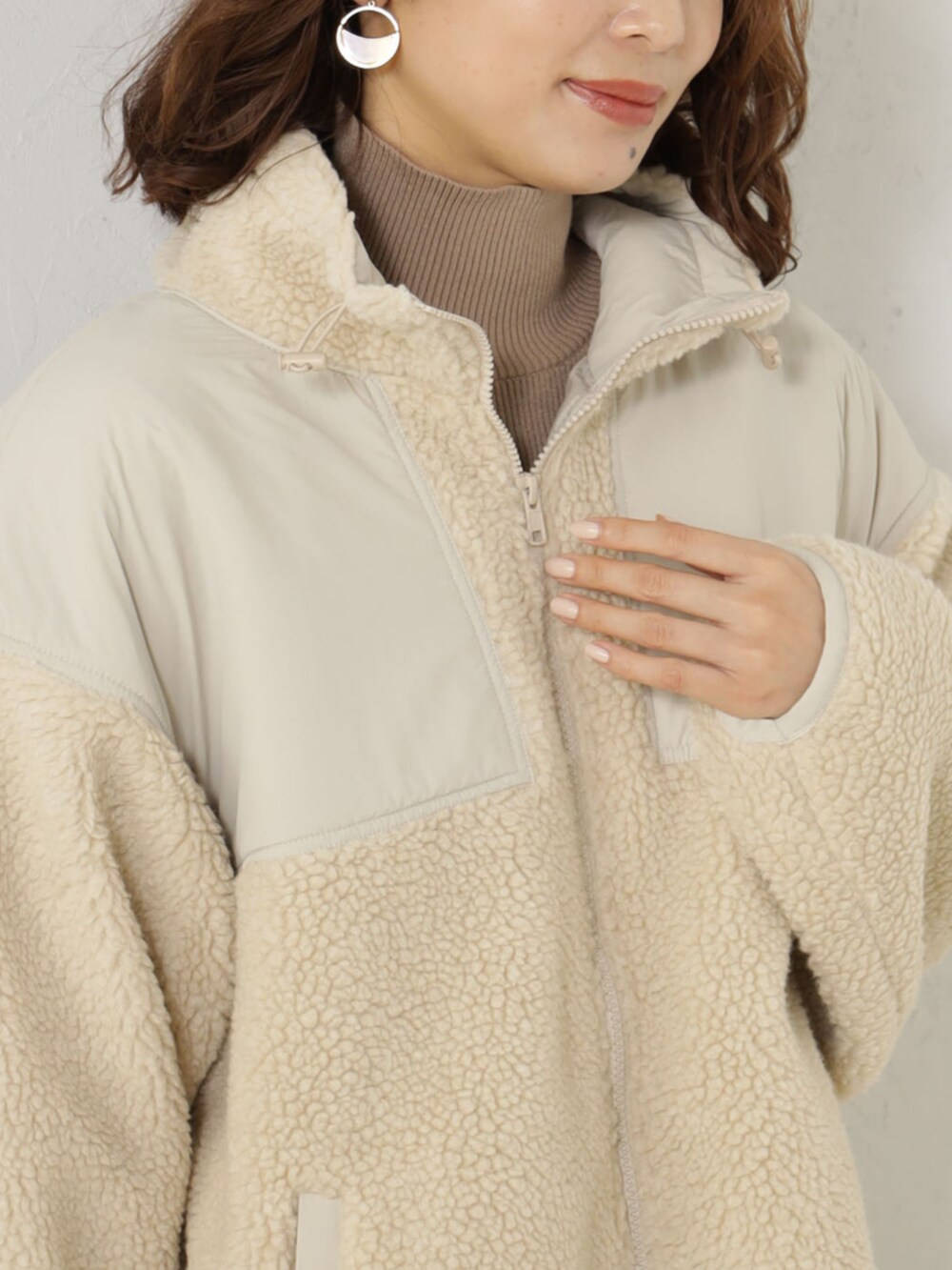 ベージュ系のブルゾン、ベージュ系のニット/セーターを着用したレディースの冬コーディネートの2枚目の写真