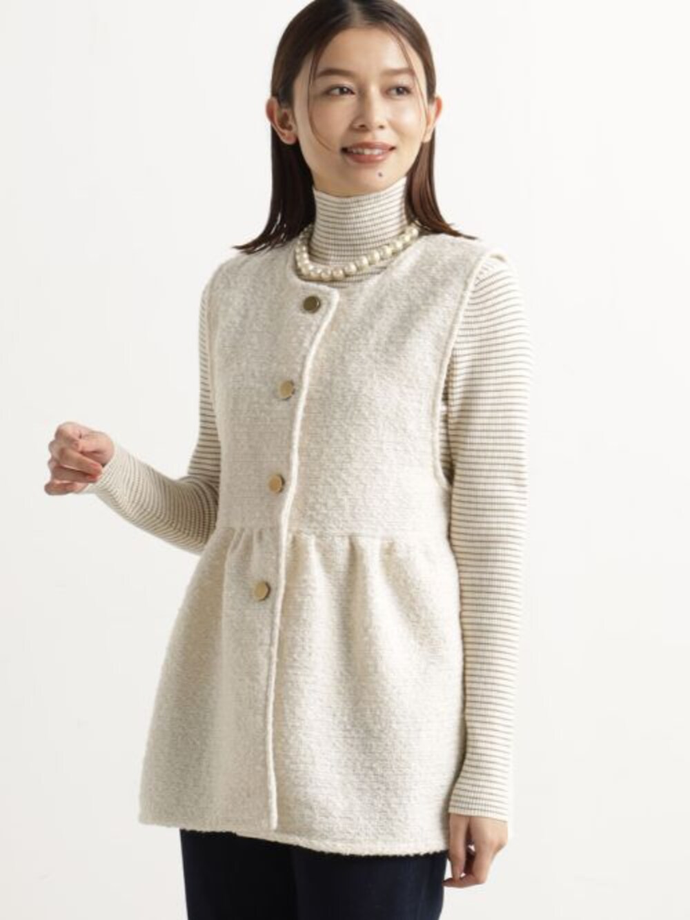 ベージュ系のベスト、ブラウン系のニット/セーター、ブルー系のその他パンツを着用したレディースの冬コーディネートの2枚目の写真