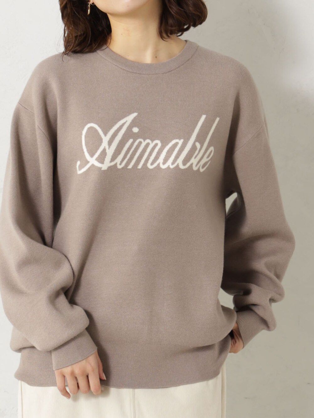 ベージュ系のブーツ、グレー系のニット/セーター、ベージュ系のスカートを着用したレディースの冬コーディネートの2枚目の写真