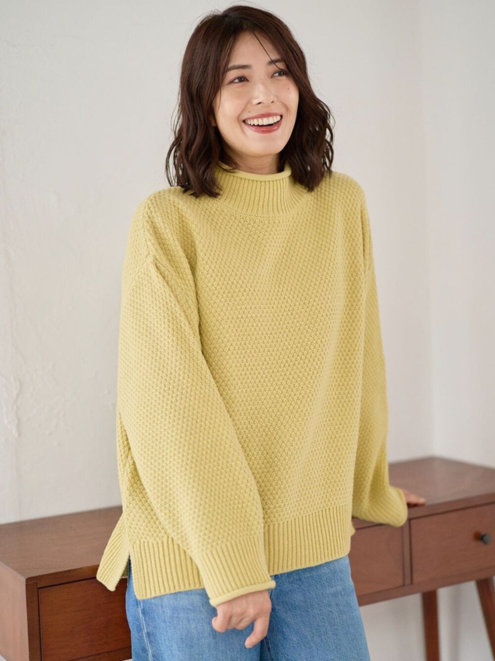 イエロー系のニット/セーターを着用したレディースの秋コーディネートの2枚目の写真