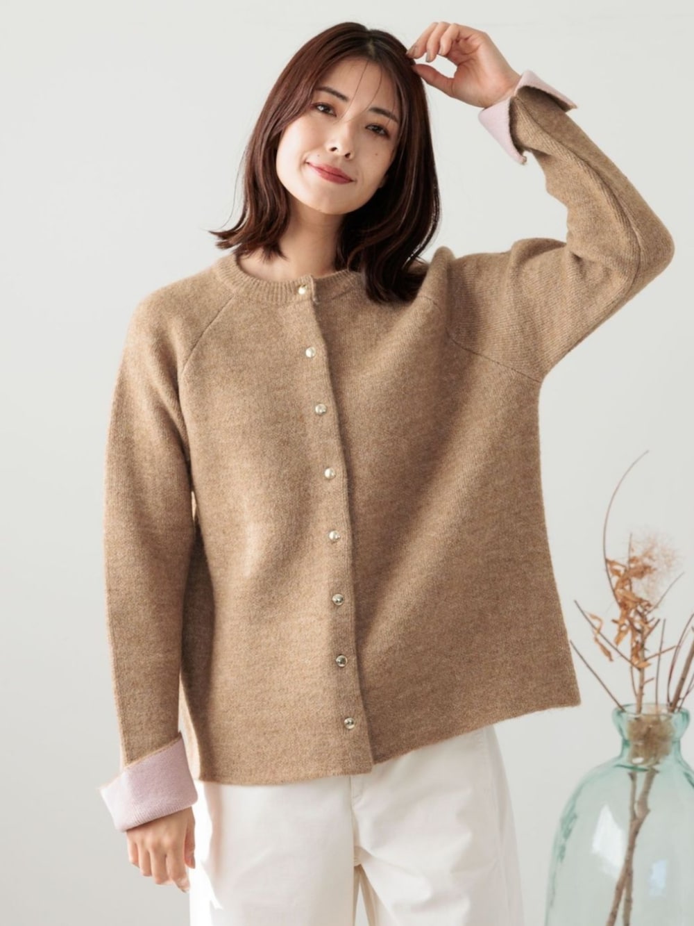 ベージュ系のカーディガン/ボレロを着用したレディースの冬コーディネートの2枚目の写真