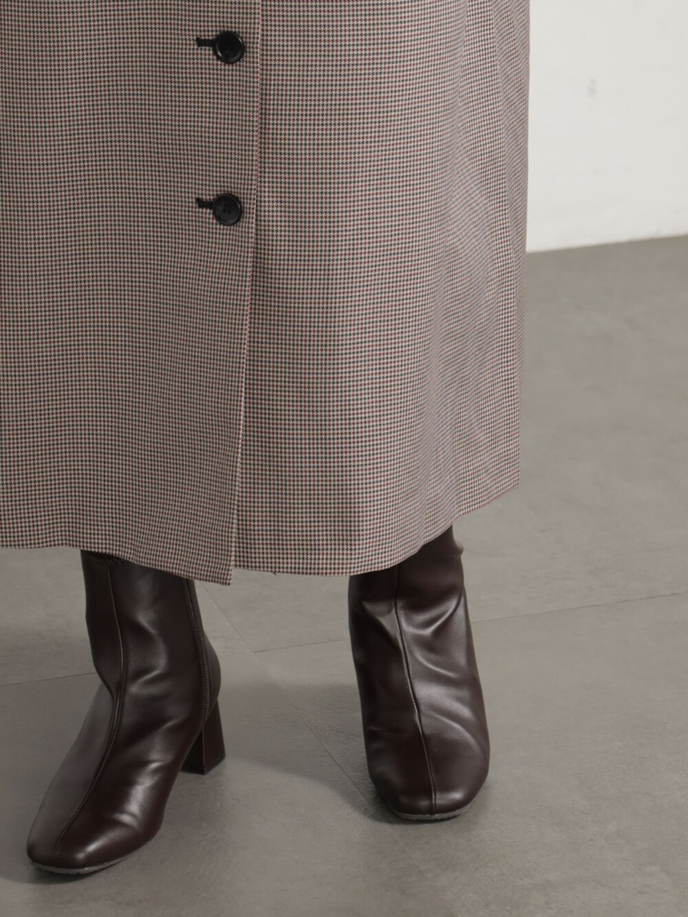 レッド系のワンピース、ブラウン系のブーツを着用したレディースの秋コーディネートの3枚目の写真