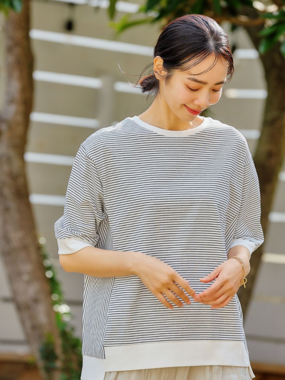 グレー系のTシャツ/カットソーを着用したレディースの春コーディネートの2枚目の写真