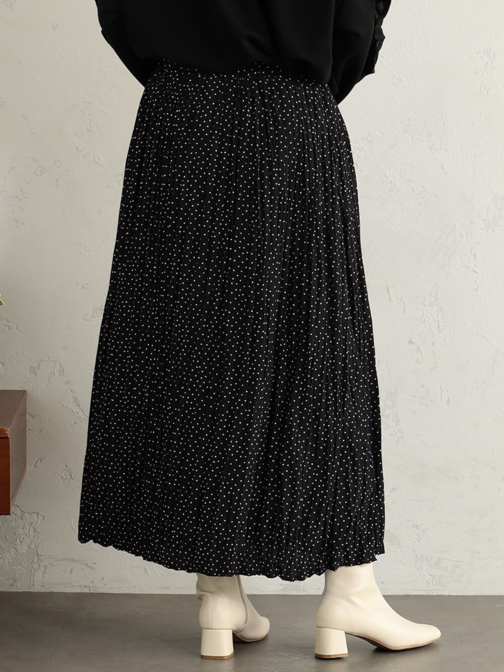 ベージュ系のブーツ、ブラック系のTシャツ/カットソー、ベージュ系のスカートを着用したレディースの冬コーディネートの3枚目の写真