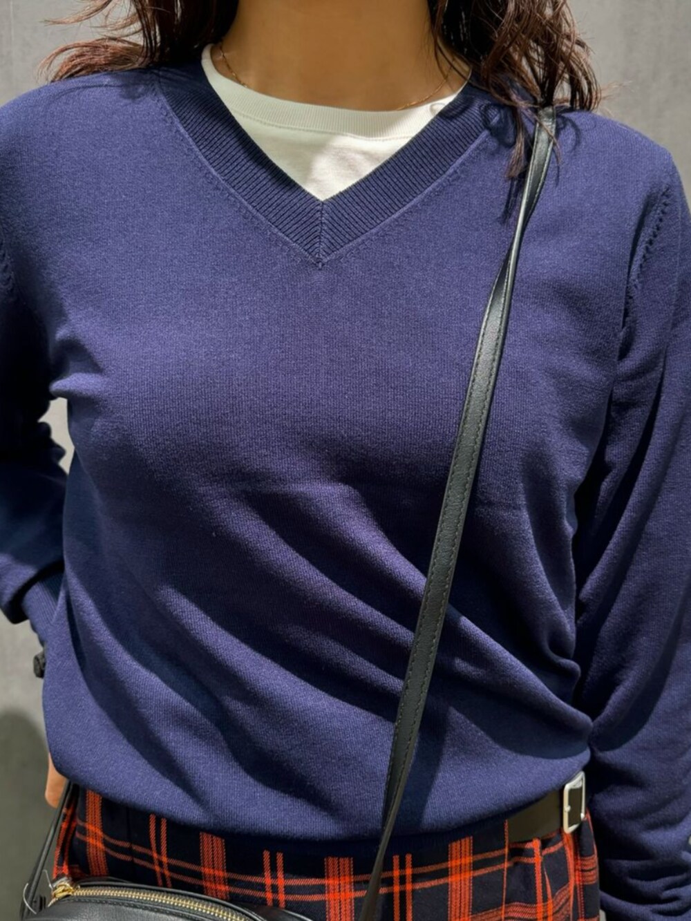 ブラック系のショルダーバッグ、ブルー系のニット/セーター、ブルー系のスカートを着用したレディースの秋コーディネートの2枚目の写真