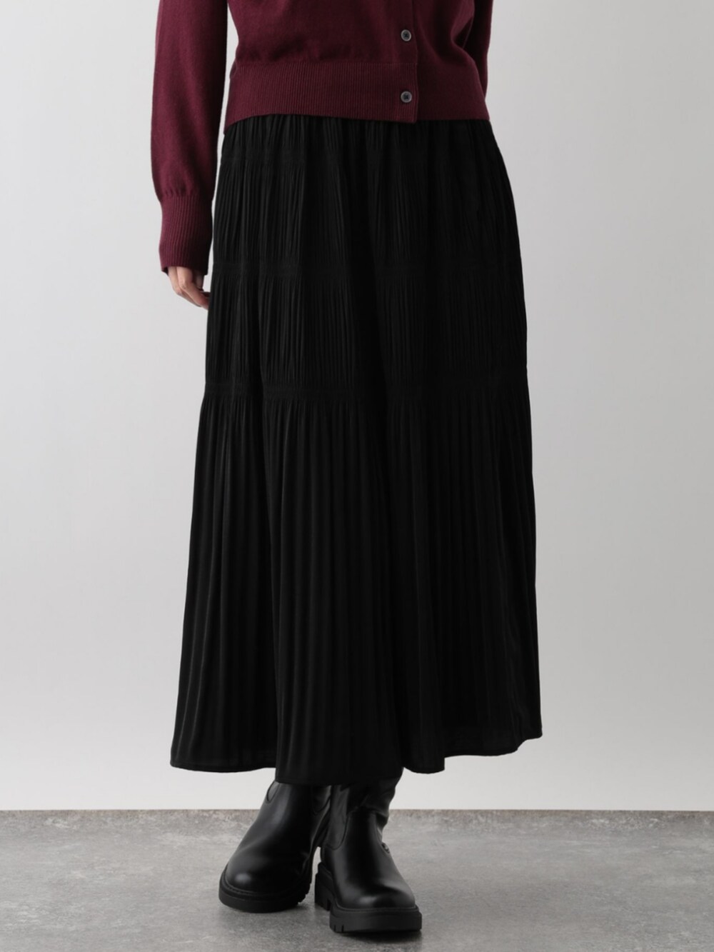 レッド系のカーディガン/ボレロ、ホワイト系のスカート、ブラック系のスカートを着用したレディースの冬コーディネートの3枚目の写真