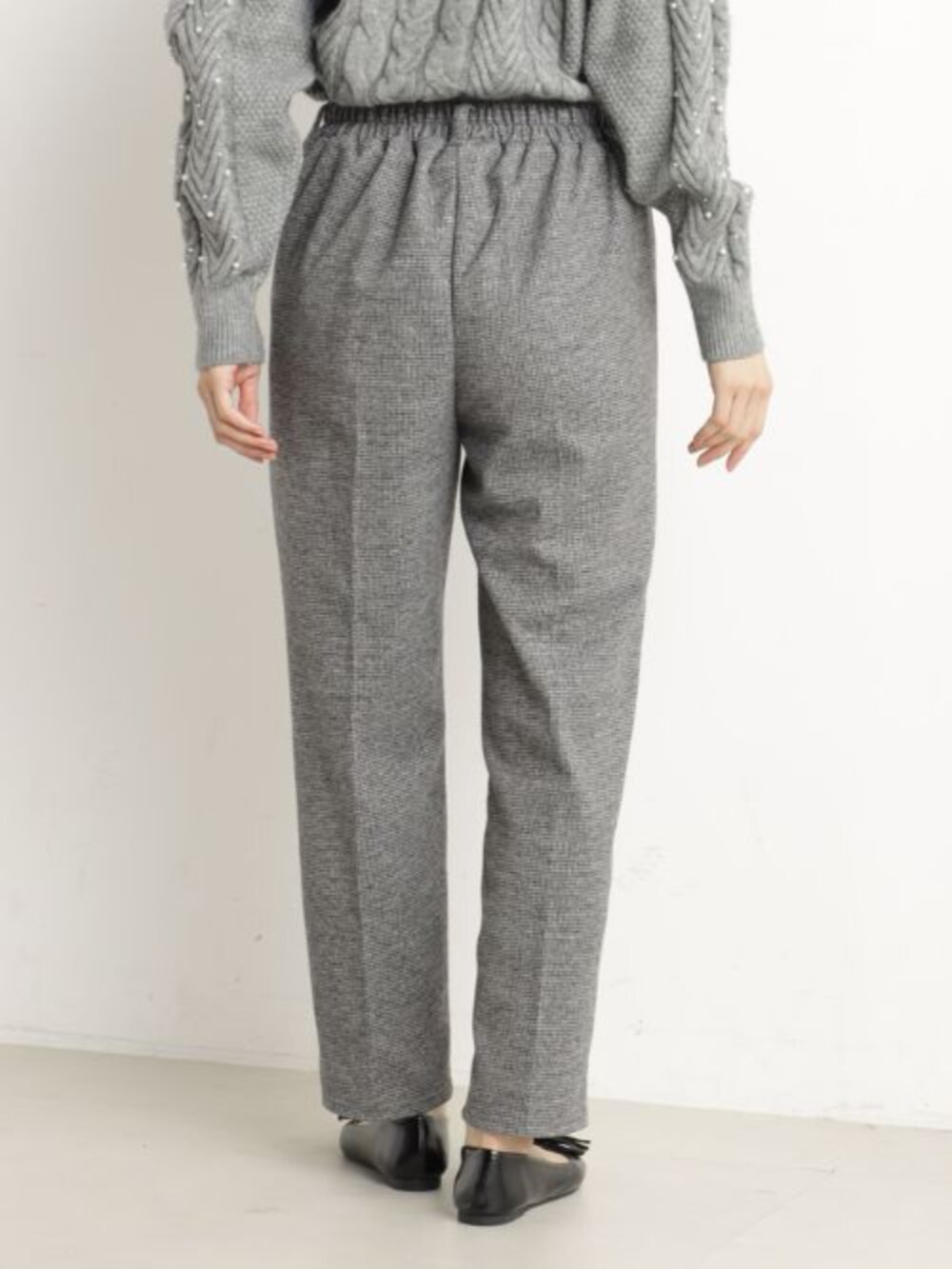 ブラック系のボストンバッグ、ブラック系のパンプス、グレー系のニット/セーターを着用したレディースの冬コーディネートの3枚目の写真