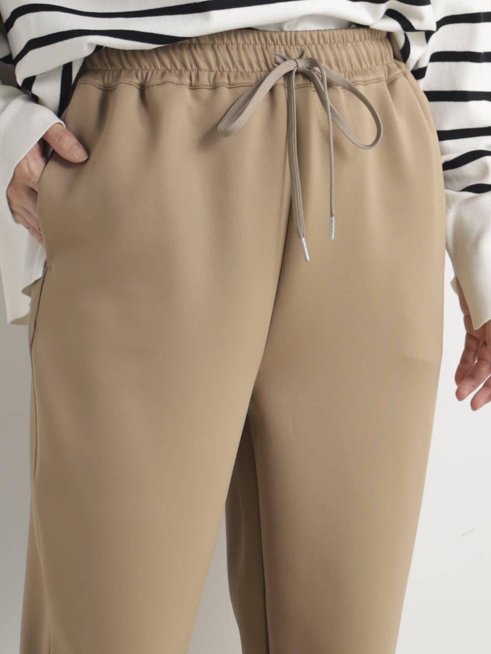 グレー系のニット/セーター、ブラウン系のその他パンツを着用したレディースの春コーディネートの4枚目の写真